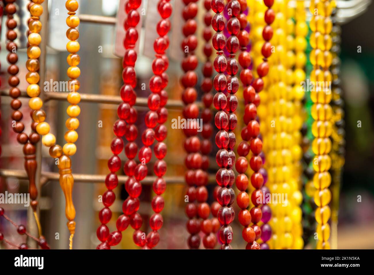 colorful rosaries in the sunlight, sales aisle Stock Photo