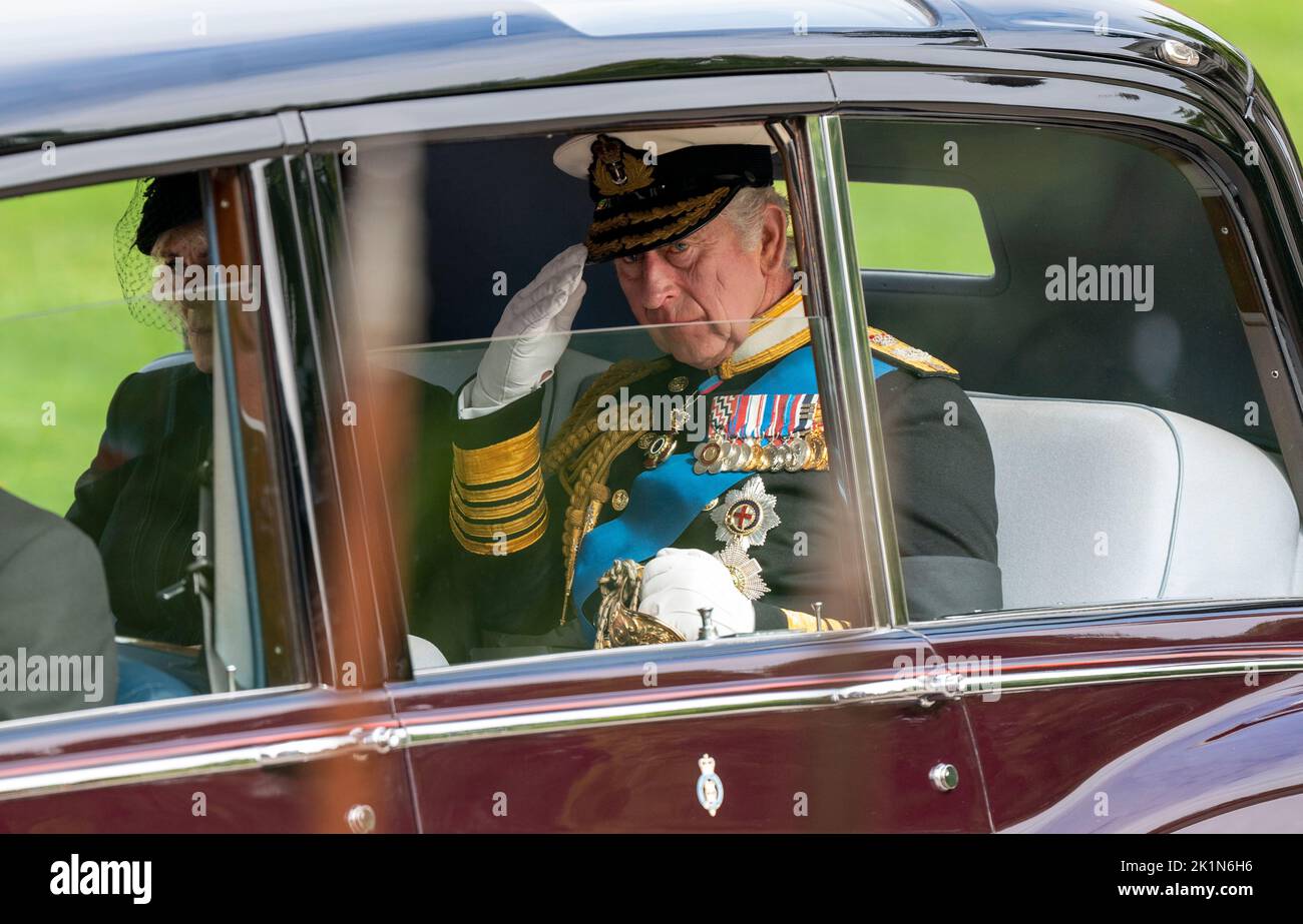 King Charles III salutes as he leaves in a car following the the coffin of Queen Elizabeth II as it departs from at Wellington Arch during the Ceremonial Procession after her State Funeral at Westminster Abbey, London. Stock Photo