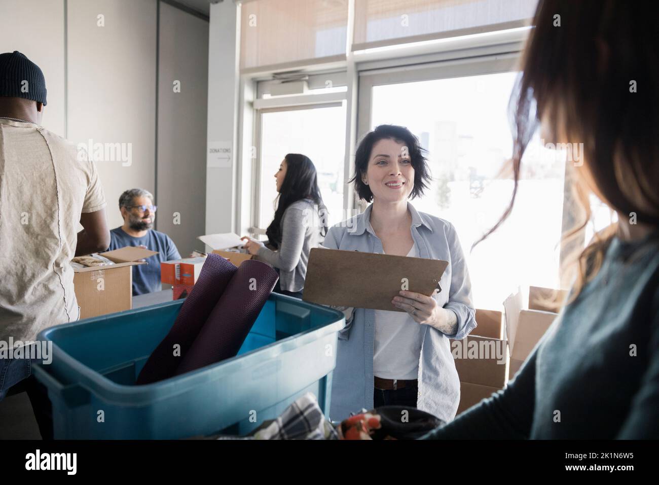 Female volunteer with clipboard in community center Stock Photo