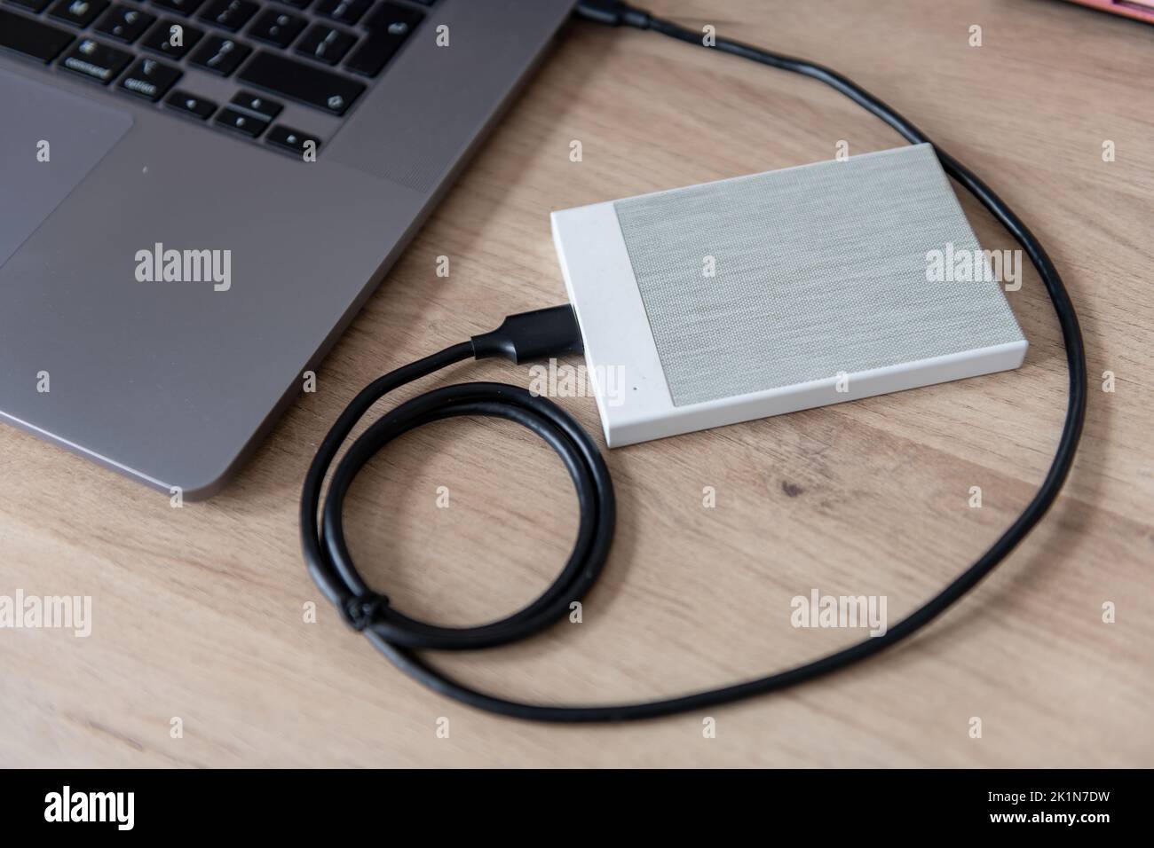 A external hard drive, file storage device connected to a laptop computer. Stock Photo