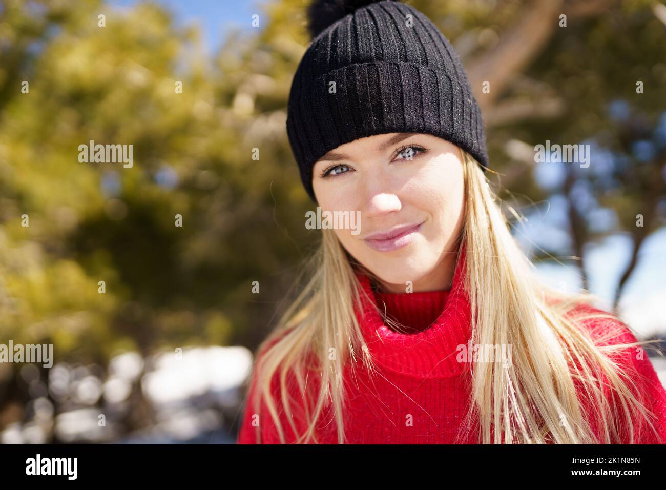 Young blonde woman in a snowy forest in the mountains in winter, in Sierra Nevada, Granada, Spain. Stock Photo