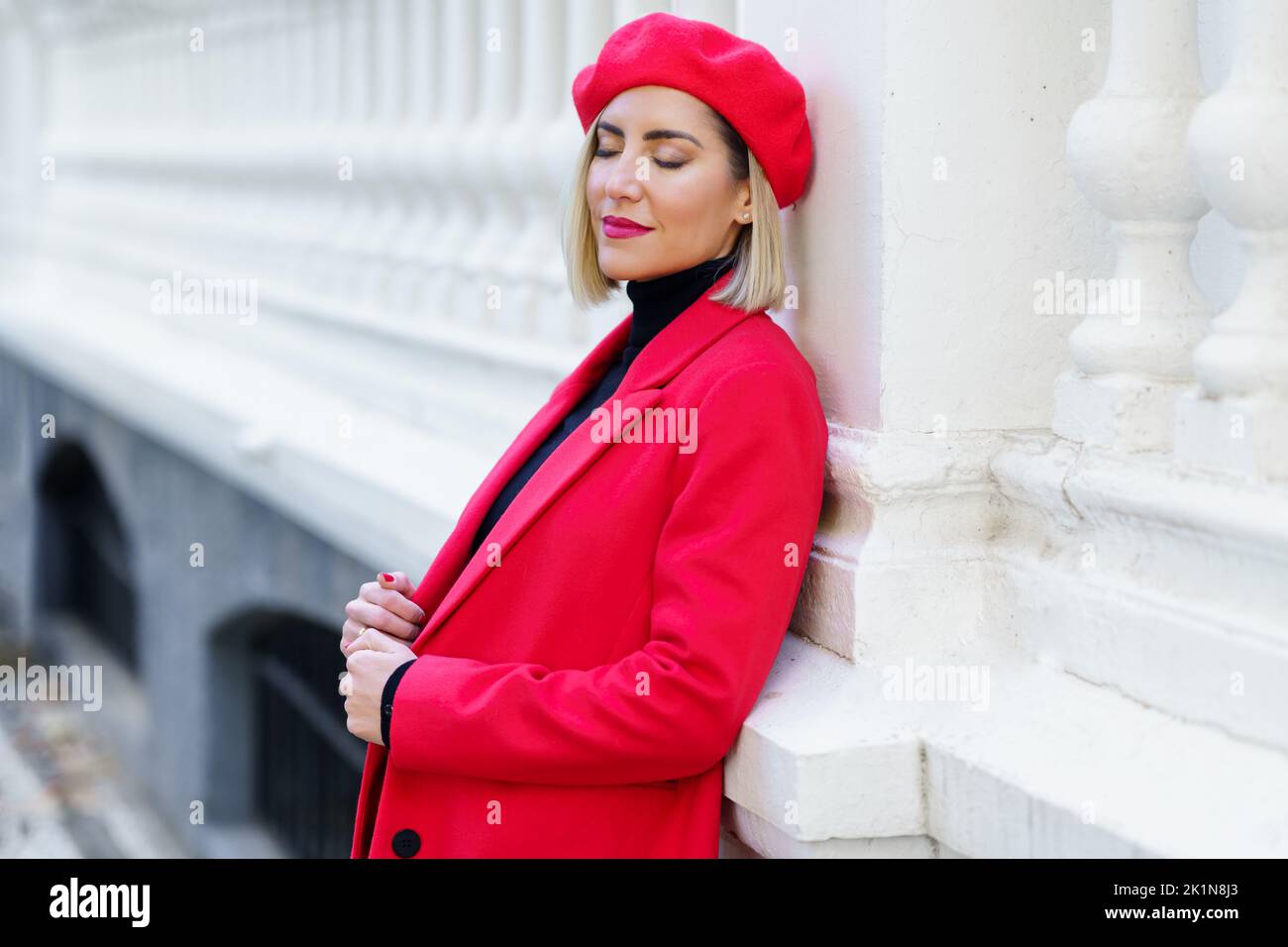 Charming woman in red outfit near fence Stock Photo