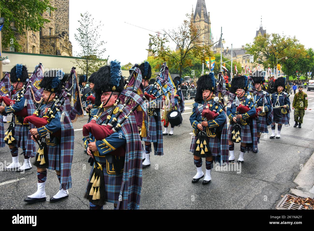 Ottawa, Canada - September 19, 2022: Marching band with bagpipers during a memorial parade on Wellington Street heading towards Christ Cathedral an Anglican church for a commemorative ceremony for the funeral of Queen Elizabeth II. The federal government declared the day a federal holiday and a national day of mourning for the Queen, with federal public servants having the day off. Stock Photo