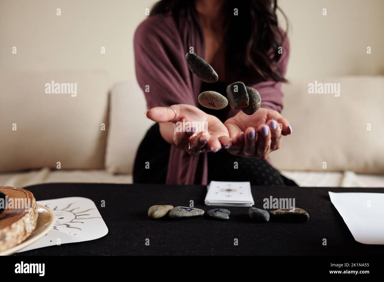 Fortune teller throwing runes on table when performing divination
