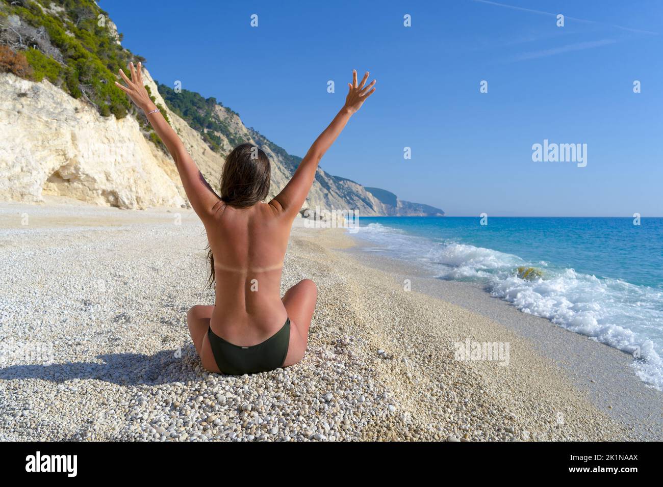 Beautiful woman enjoying her freedom by the sea with arms open Stock Photo