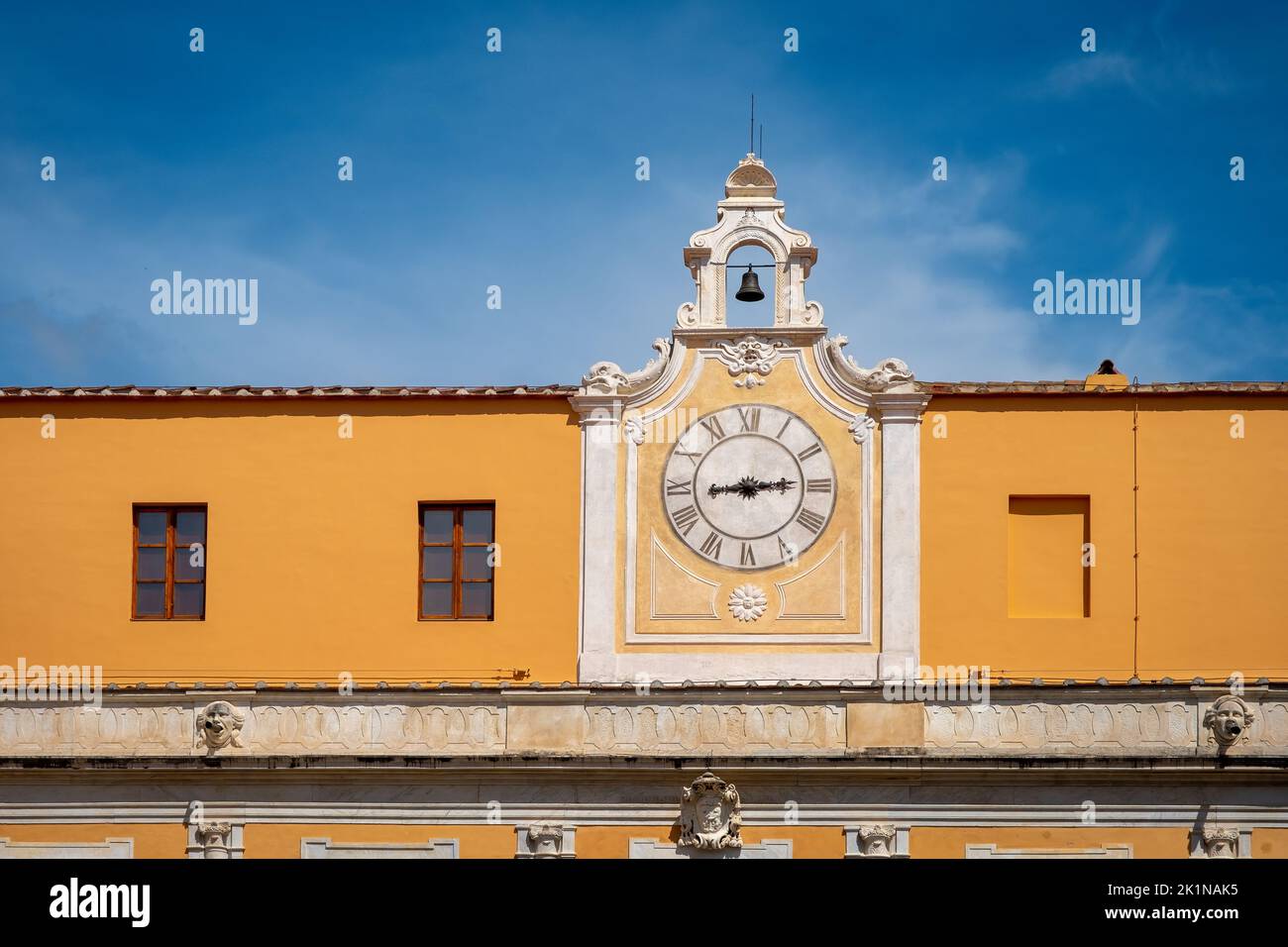 Pisa, Italy - June 8, 2022: Beautiful, ornate clock set in orange colored wall in Pisa, Italy. Stock Photo