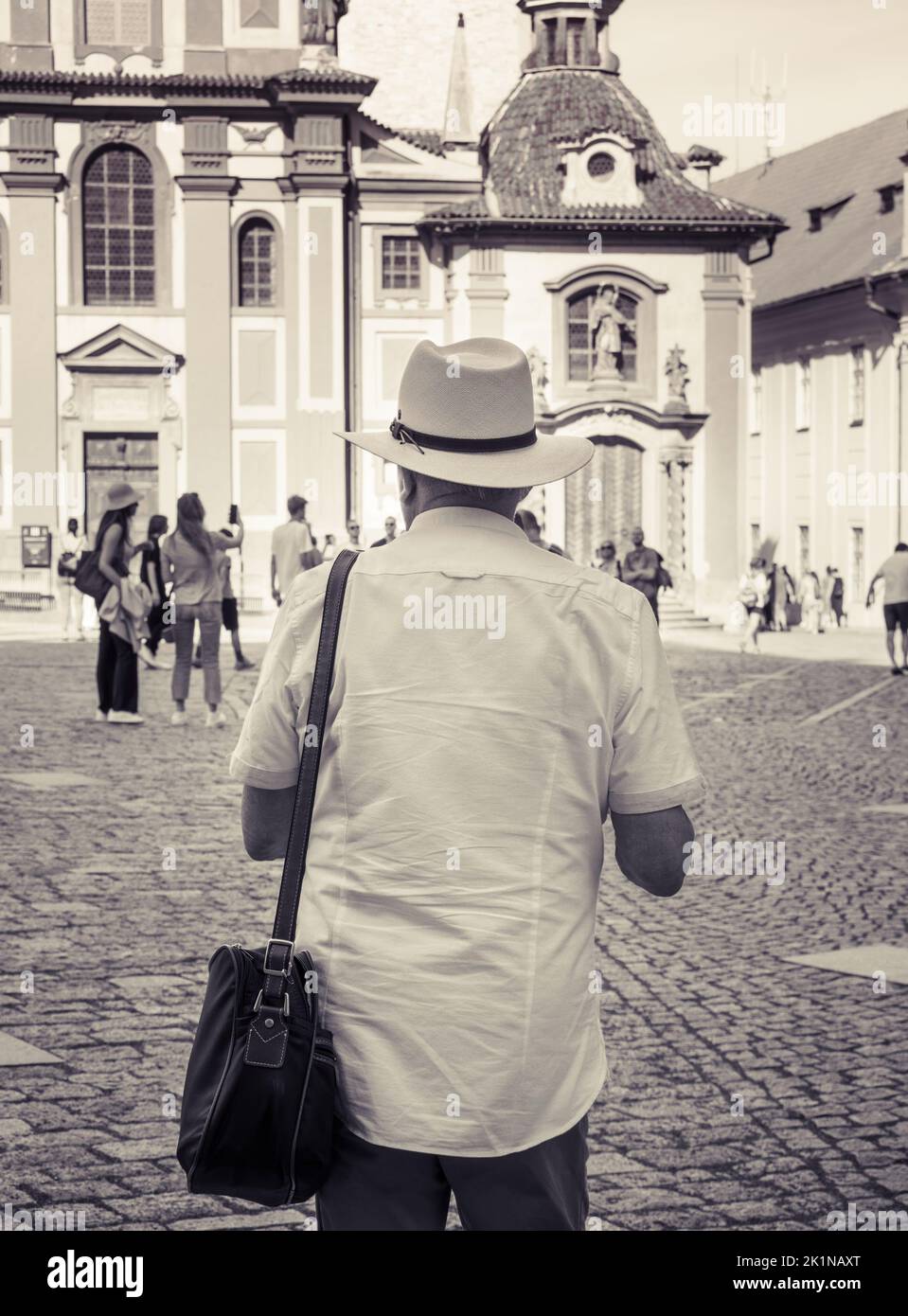 Black and white photography of a tourist man wearing a white hat. Rear ...
