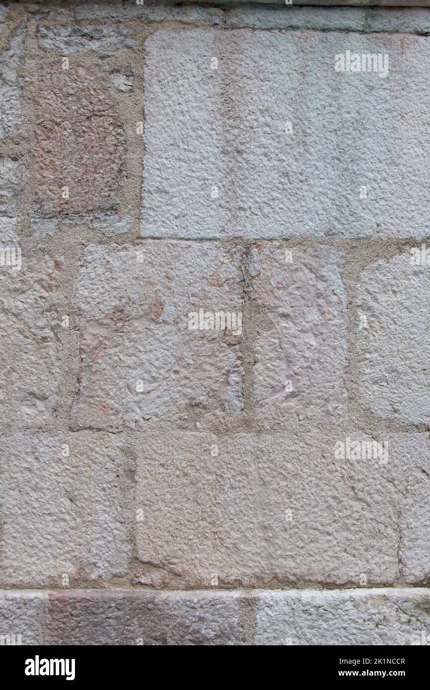 Close up white beige historic old structured bricked facade wall as background with stone blocks rectangular shaped Stock Photo