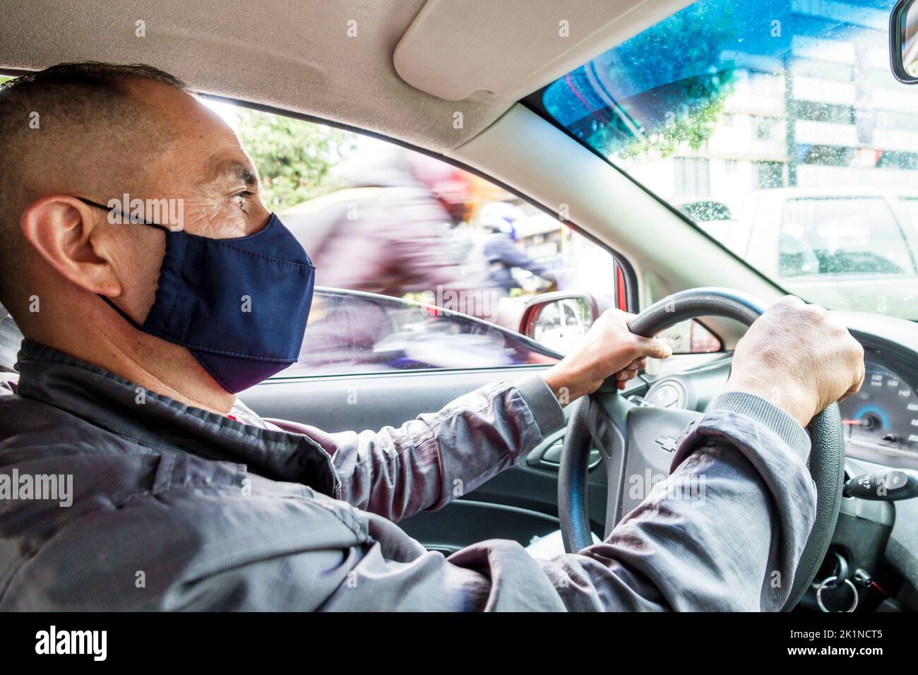 Bogota Colombia,Carrera 24 Uber driver driving,Covid 19 health crisis pandemic corona virus wearing face mask covering,Colombian Colombians Hispanic H Stock Photo