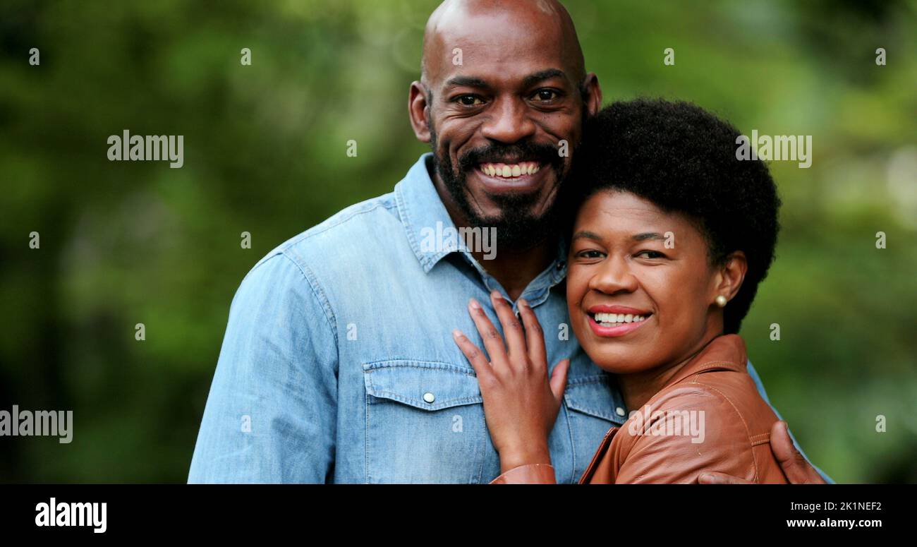 African couple embracing together outside portraits looking at camera ...