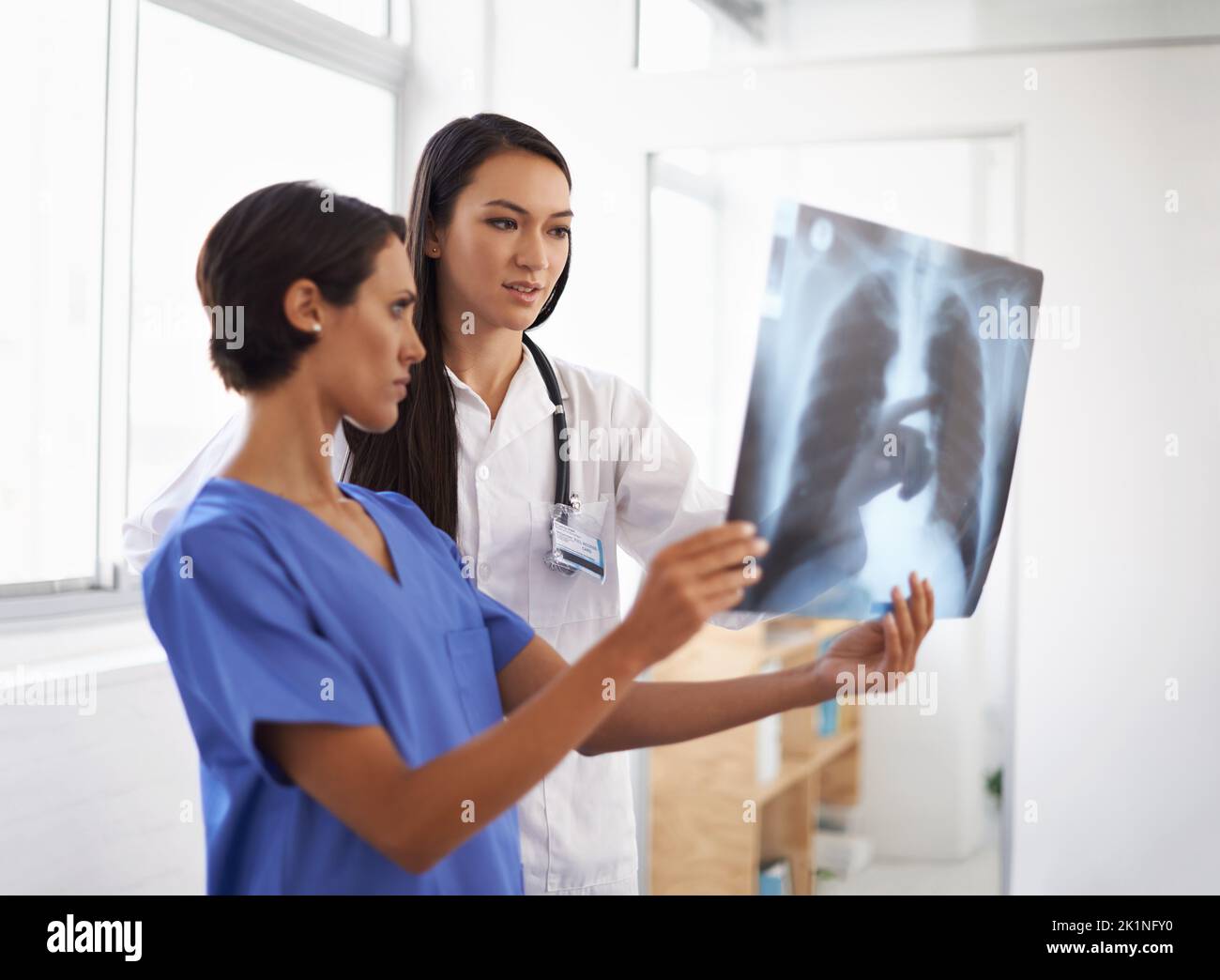 Pinpointing the problem. a doctor and her assistant checking some xrays ...