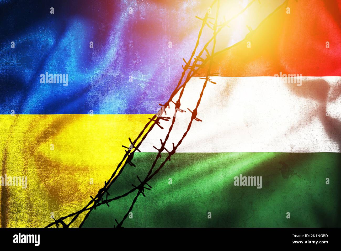 Grunge flags of Ukraine and Hungary divided by barb wire illustration sun haze view, concept of tense relations between two countries Stock Photo