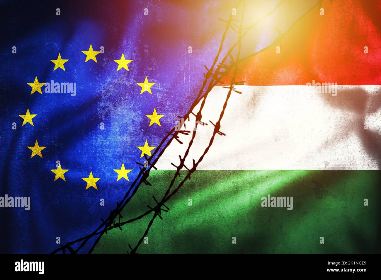 Grunge flags of EU and Hungary divided by barb wire illustration sun haze view, concept of tense relations between and dispute of European union and H Stock Photo