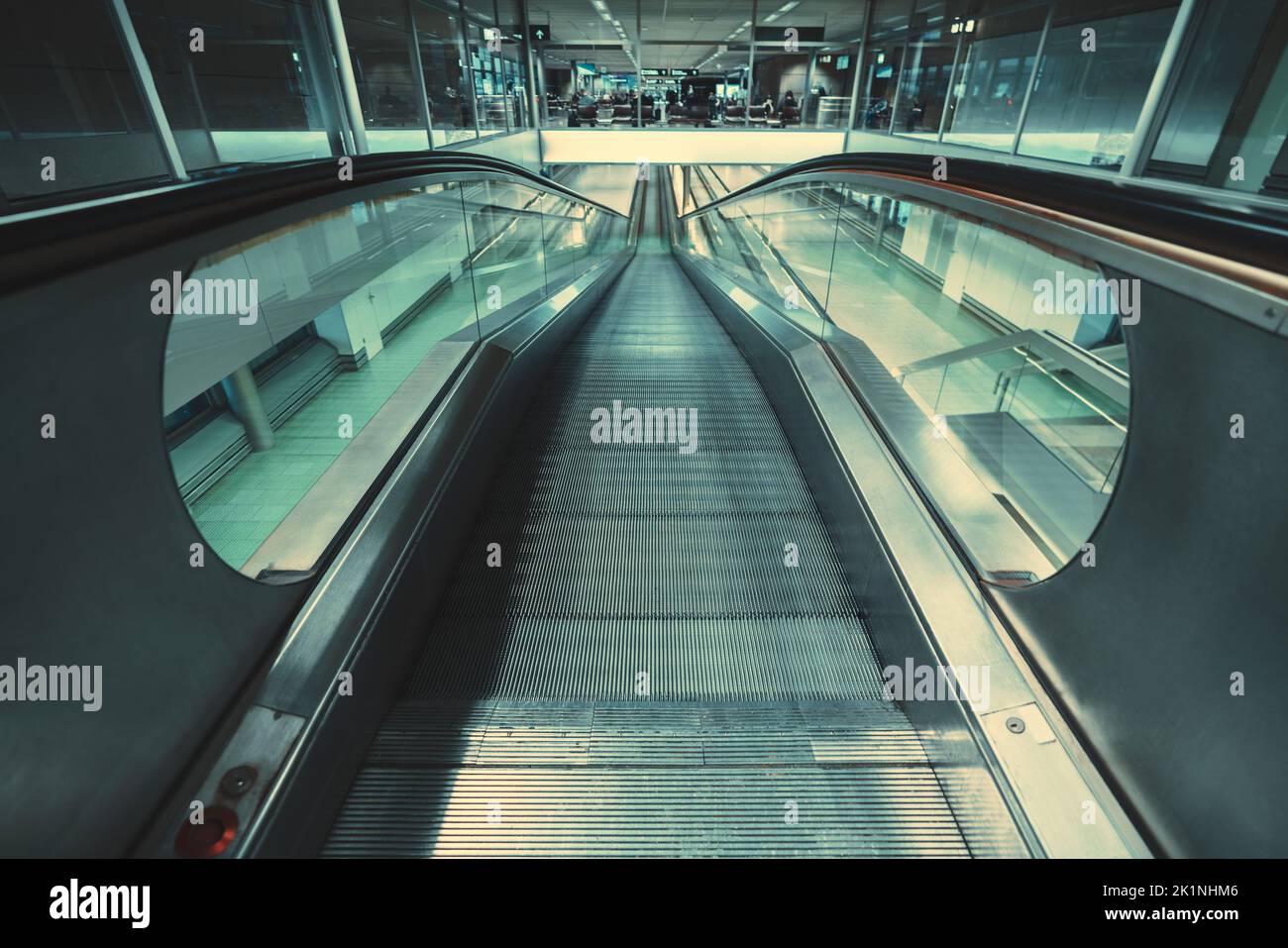 Inner view of a modern chrome moving walkway illuminated with neon light in an international airport or shopping mall, or a railway depot, with the se Stock Photo