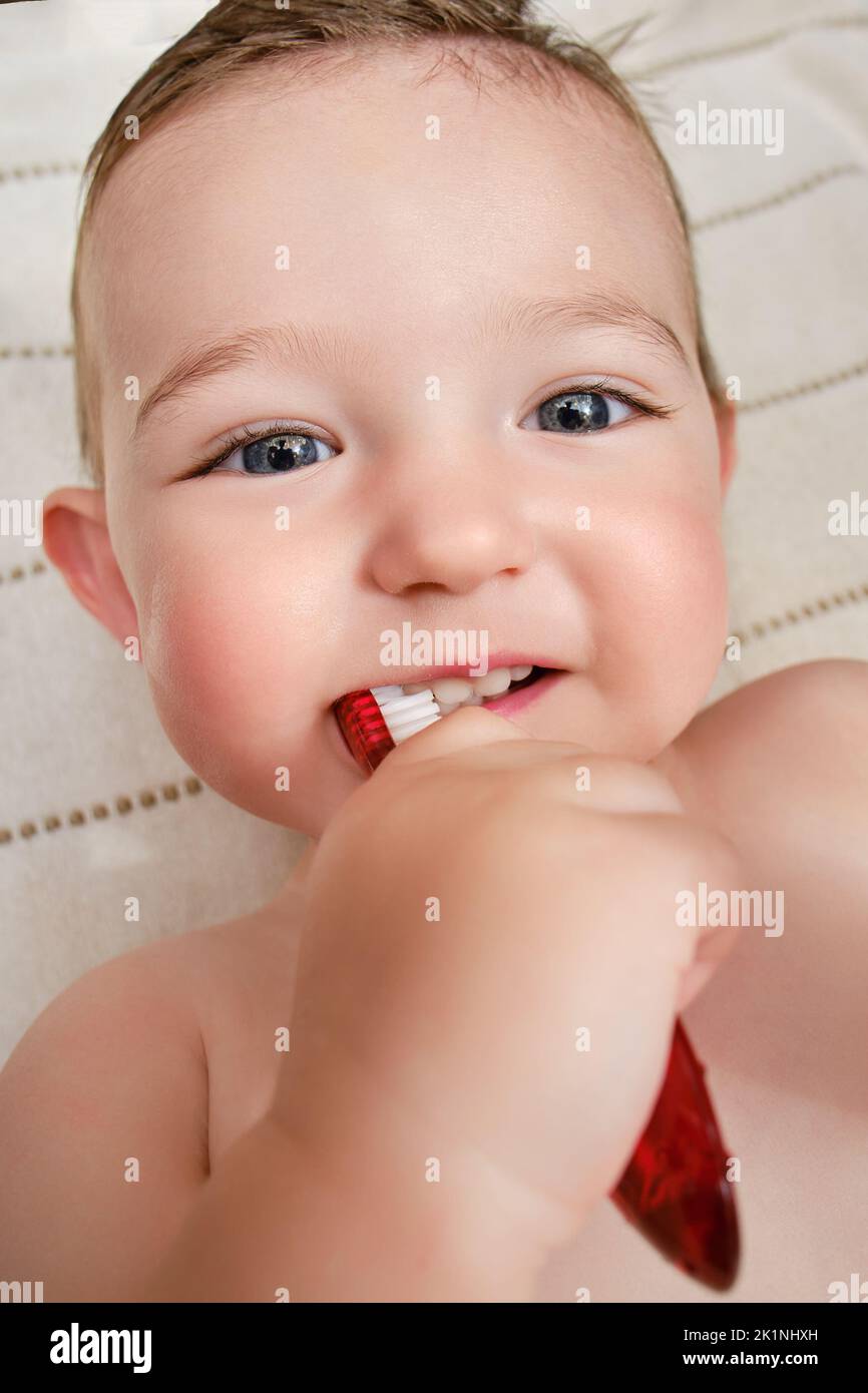 Happy toddler baby brushes his teeth with a toothbrush. A smiling child