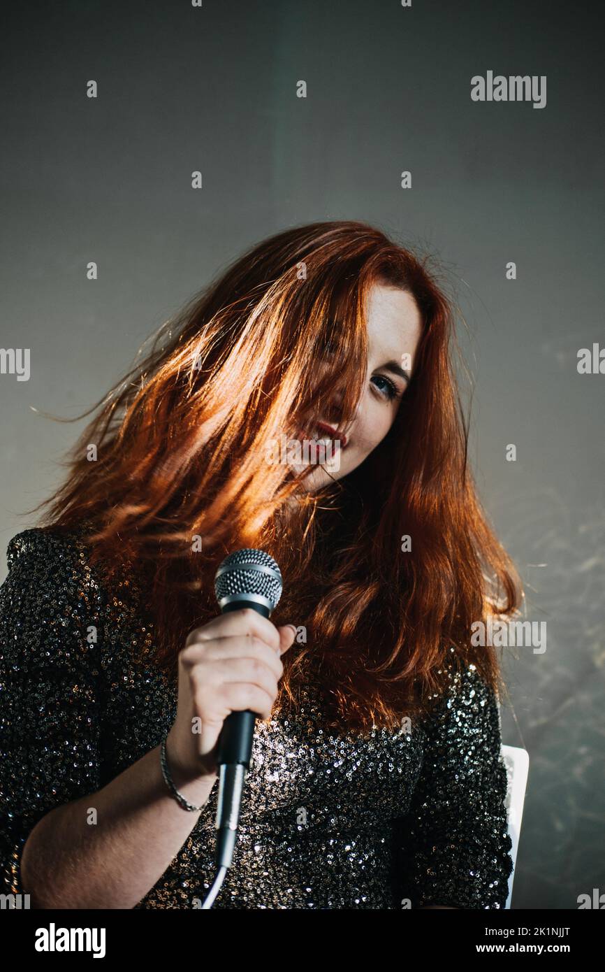 Portrait of redhead female singer woman in sparkly evening dress ...