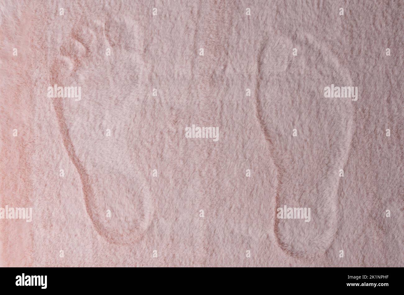 Pair of barefoot trace on pink soft fluffy carpet above top view Stock Photo