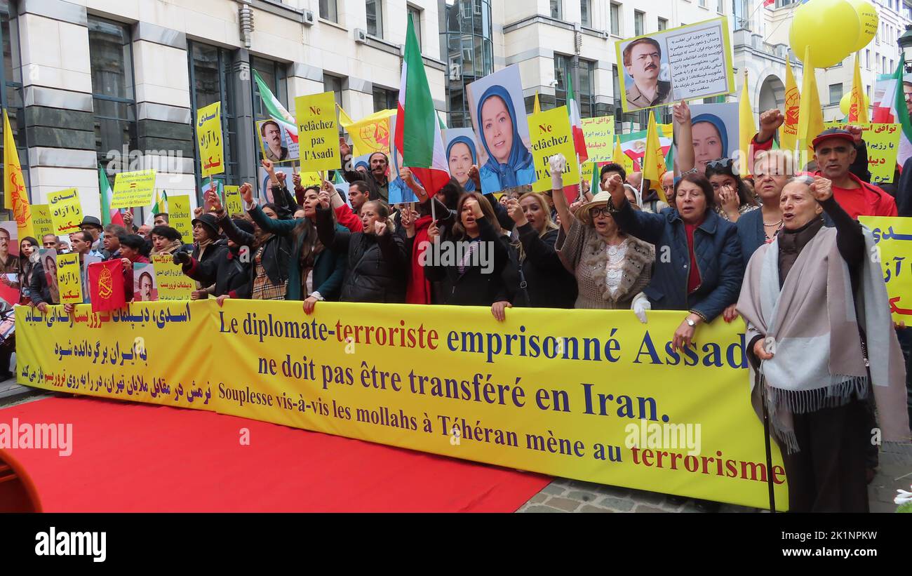 Protesters hold a banner and placards during the demonstration. Iranians took part in a rally in front of the Belgium Foreign Ministry in Brussels while carrying photos of Maryam Rajavi, the Iranian opposition leader. Iranians urged the government to cancel the agreement that sets the stage for the return of Assadollah Assadi, an Iranian diplomat to Iran. Assadi was condemned to 20 years in prison by a Belgium court for masterminding a plot to bomb a major international gathering in Paris of the Iranian opposition and is currently in jail in Belgium. Stock Photo