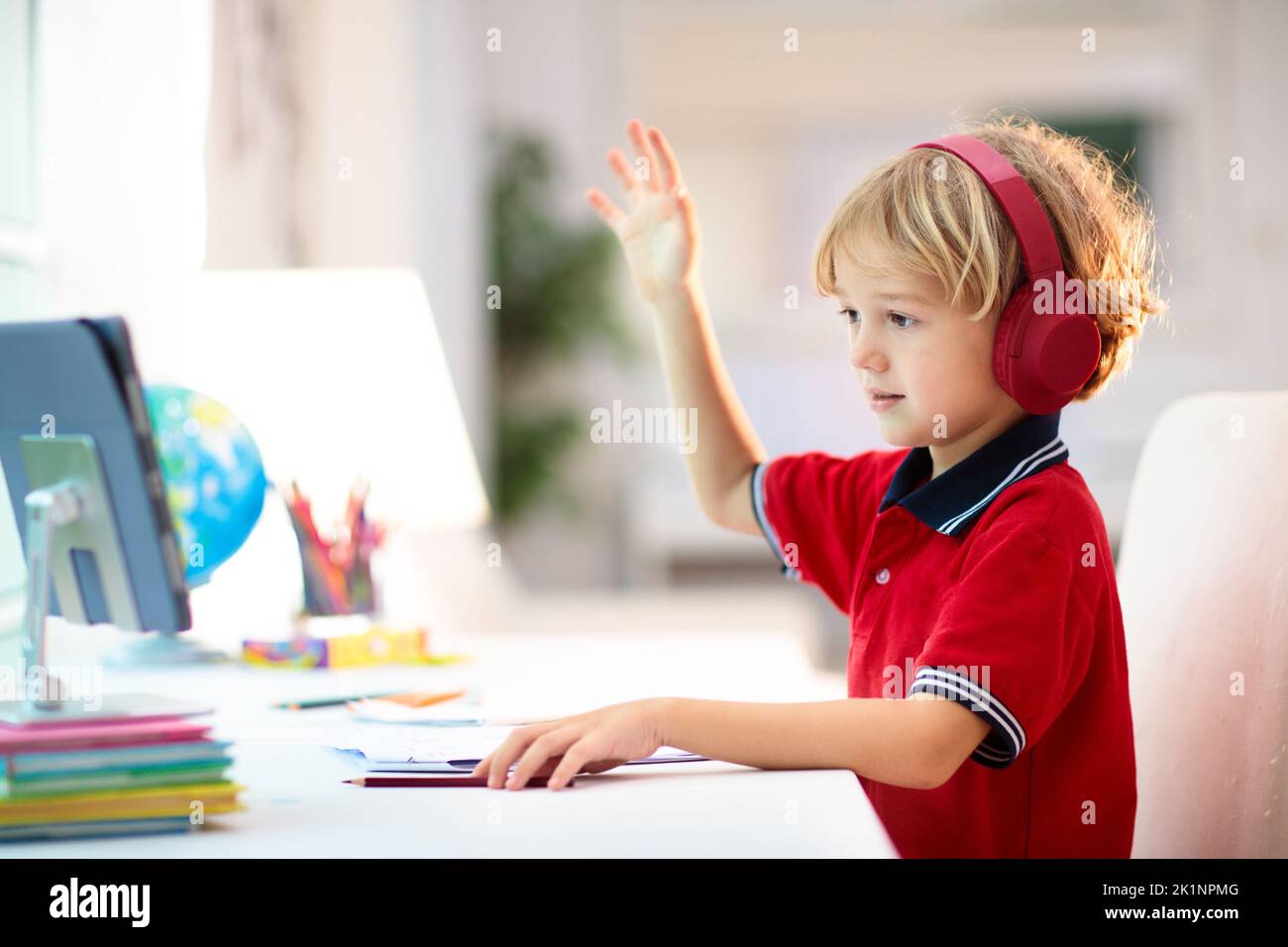 Online remote learning. School kids with computer having video conference chat with teacher and class group. Child studying from home. Homeschooling d Stock Photo