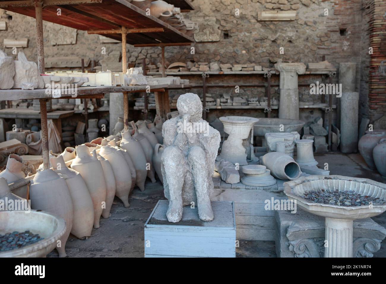 amphorae, artefacts and a cast of a body at Pompeii, in the storage area of artefacts found at the archaeological site Stock Photo