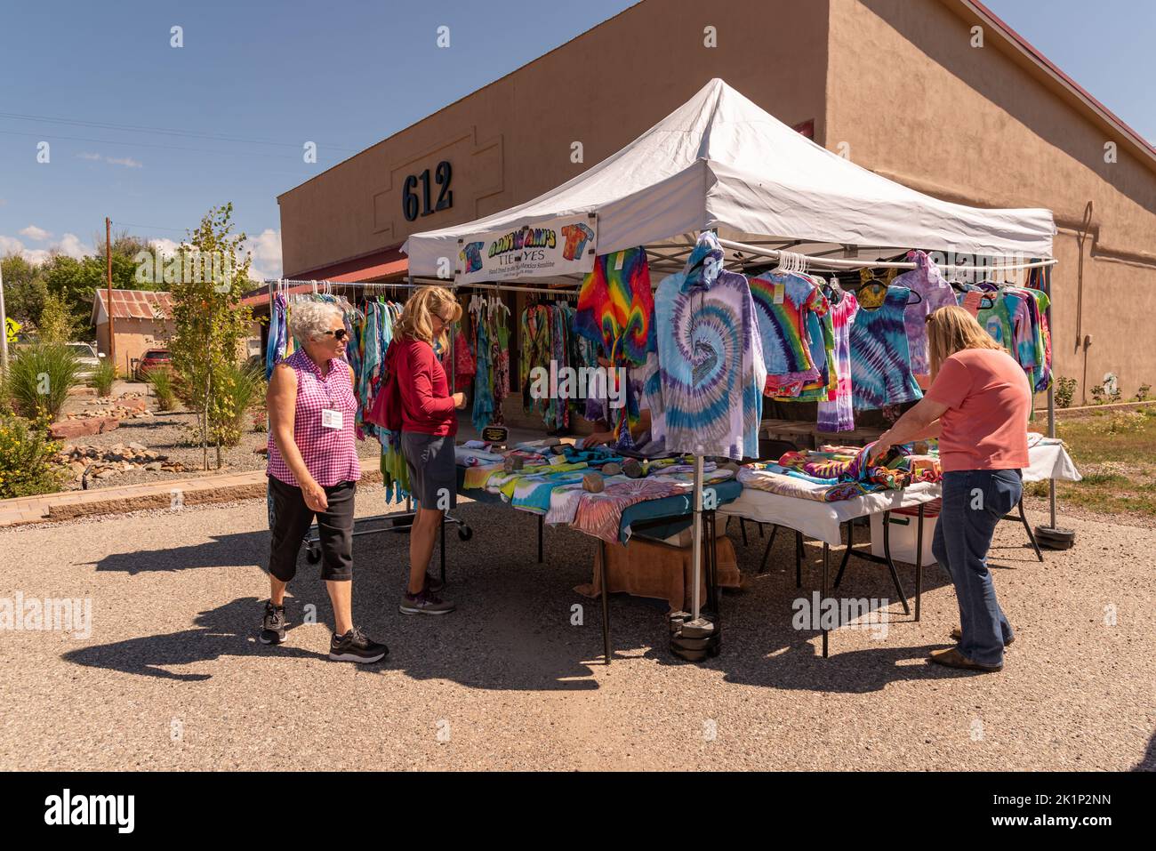 Shoppers look at Tie Dyed t-shirts at the Chama Valley Arts Festival in Chama, Rio Arriba County, New Mexico. Stock Photo