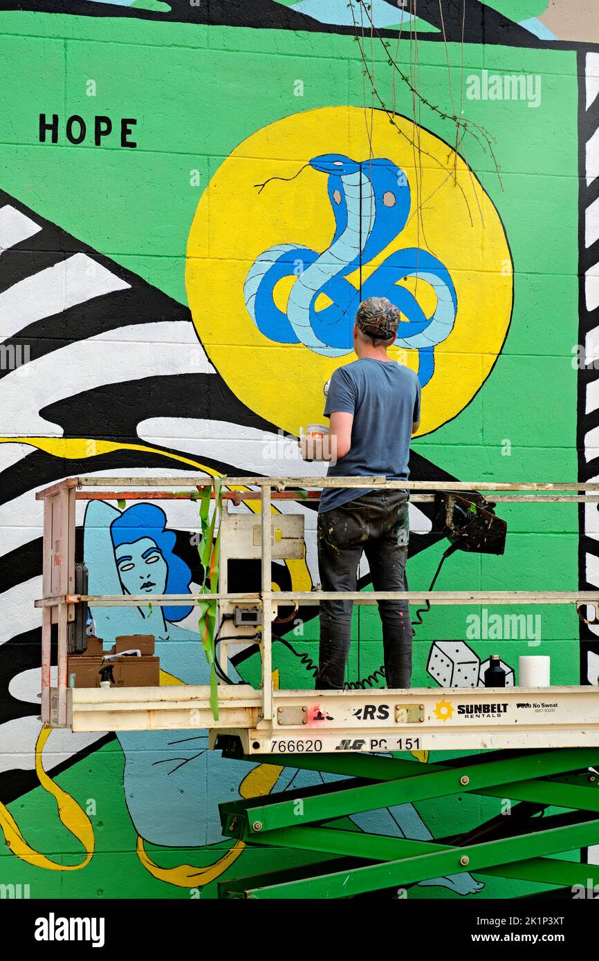 An artist creates a new mural during the 2022 RVA Street Art Festival at the Power Plant along Richmond VA's Canal Walk. Stock Photo