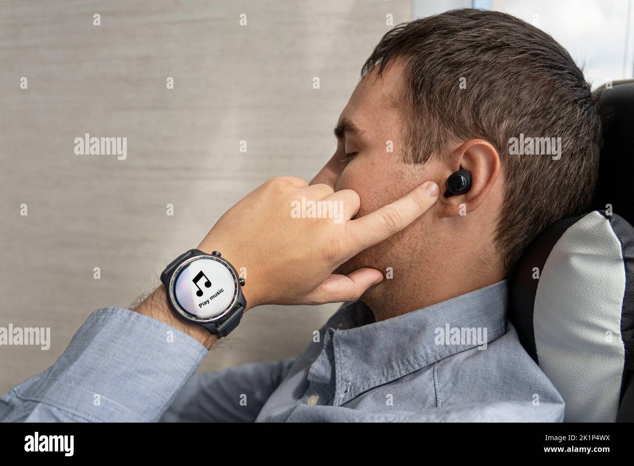 Close-up of wireless earphone in human ear on dark background. insert the earphone into the ear. listening to music with headphones. listening to musi Stock Photo