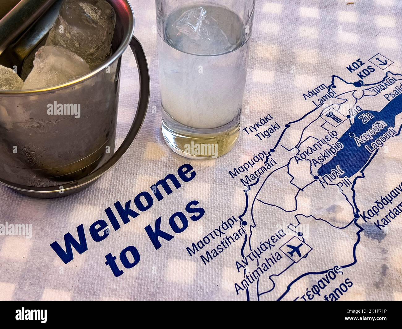 Welcome to Kos and drink a glass of ouzo. Greek Island in the Dodecanese group in Southern Aegean sea. A traditional spirit glass with a milky drink Stock Photo