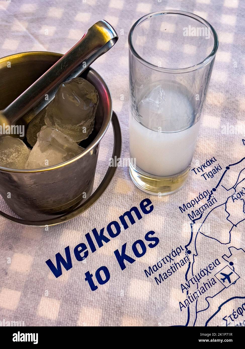 A glass of Greek ouzo in a tavern on Greek Kos island, in the Dodecanese group in Southern Aegean sea. A traditional spirit, vertical Stock Photo
