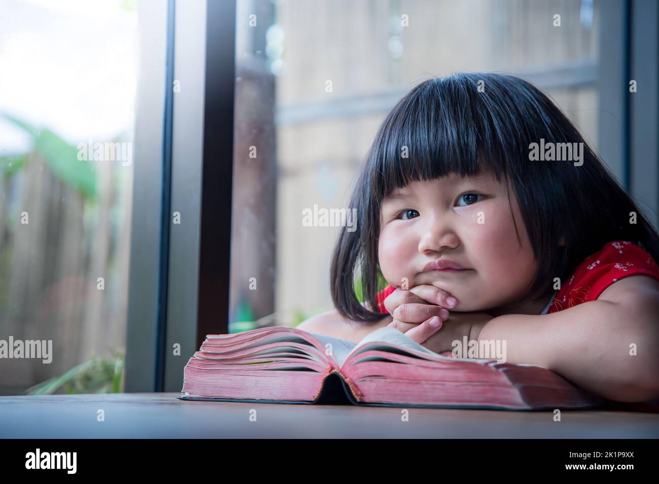 Little girl read the bible and pray at home, child's pure faith Stock Photo