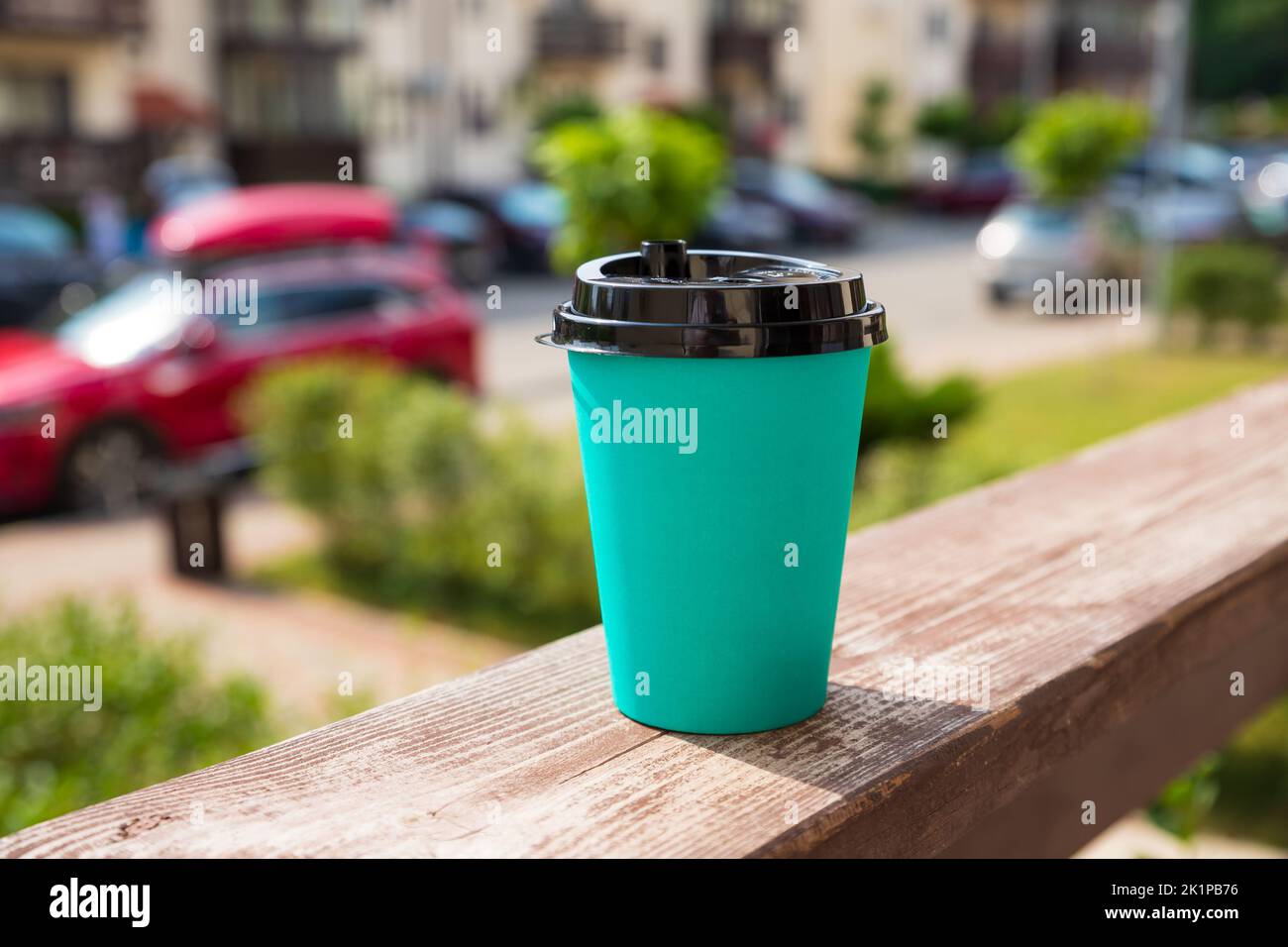 https://c8.alamy.com/comp/2K1PB76/emerald-green-color-paper-cup-with-black-lid-on-wooden-background-on-street-take-away-cup-with-plastic-lid-front-view-closeup-2K1PB76.jpg