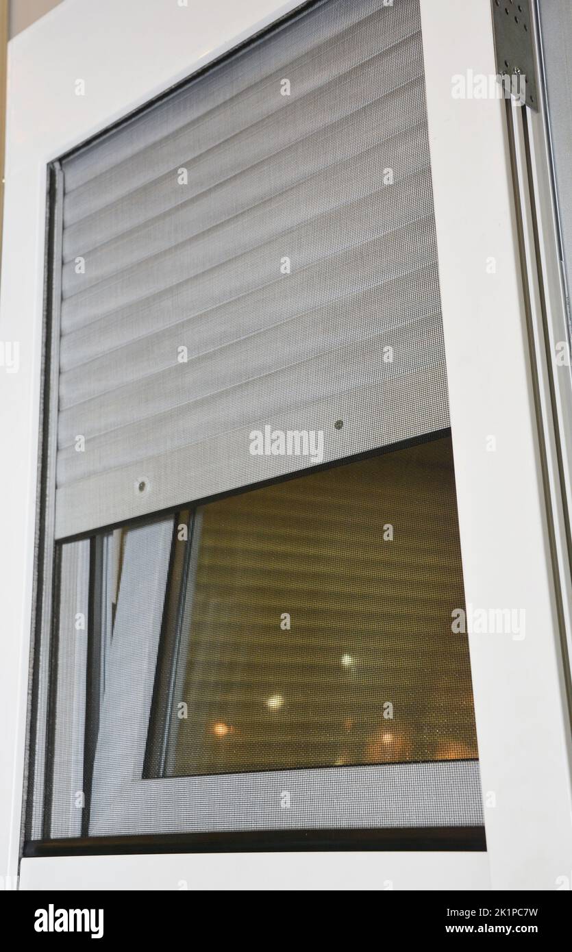 Close up on rolling shutters house windows protection with mosquito net screen. Stock Photo