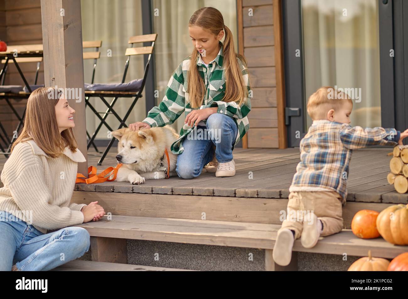 Happy young mother spending time with her children outdoors Stock Photo