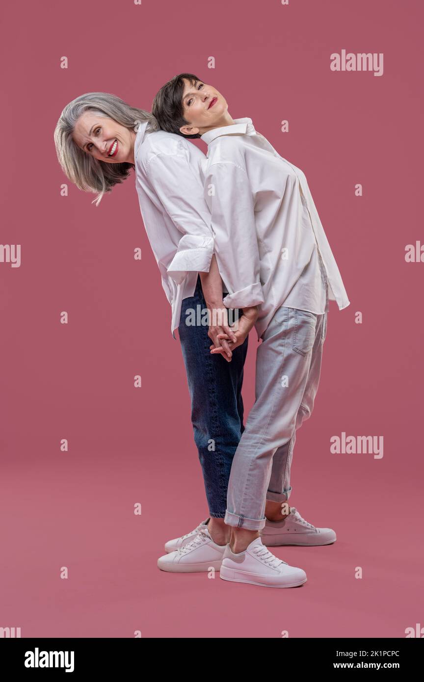 Two women standing back to back and feeling close Stock Photo