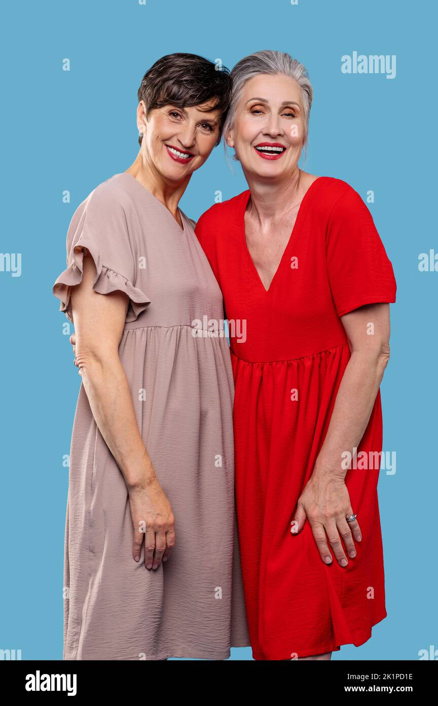 Pretty mature ladies in dresses looking happy Stock Photo