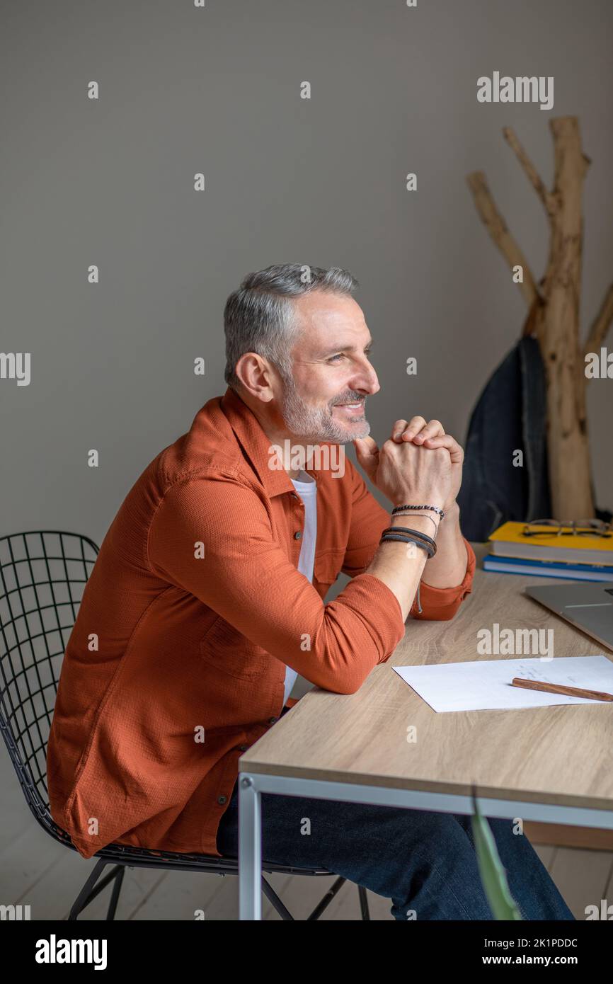 Manager sitting at the table in the office and looking thoughtful Stock Photo
