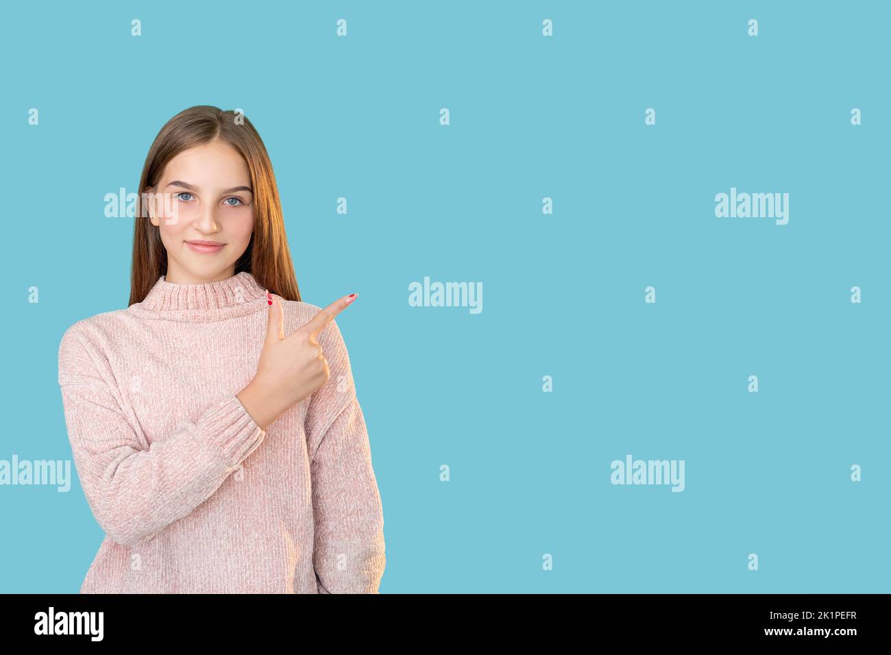 Special offer. Advertising background. Solution idea. Portrait of confident teen girl in pink sweater presenting invisible product information pointin Stock Photo