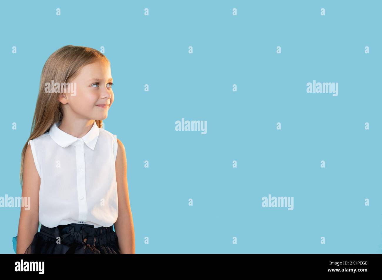 Curious kid. Advertising background. Back to school. Portrait of happy enthusiastic little girl smiling looking at invisible information isolated on b Stock Photo