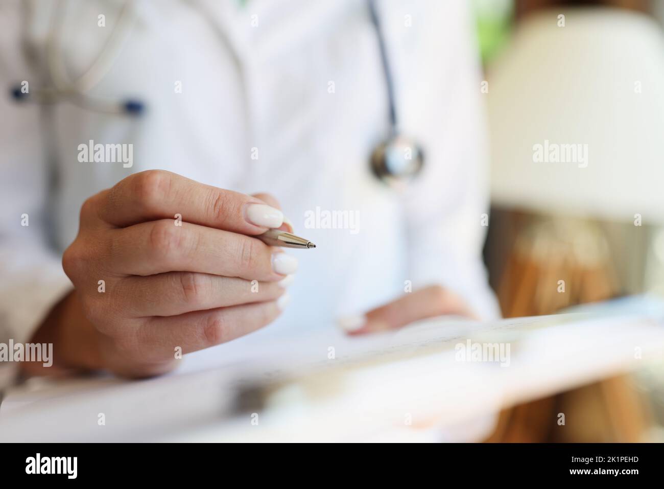 Hands of cardiologist or pediatrician doctor take notes with pen with