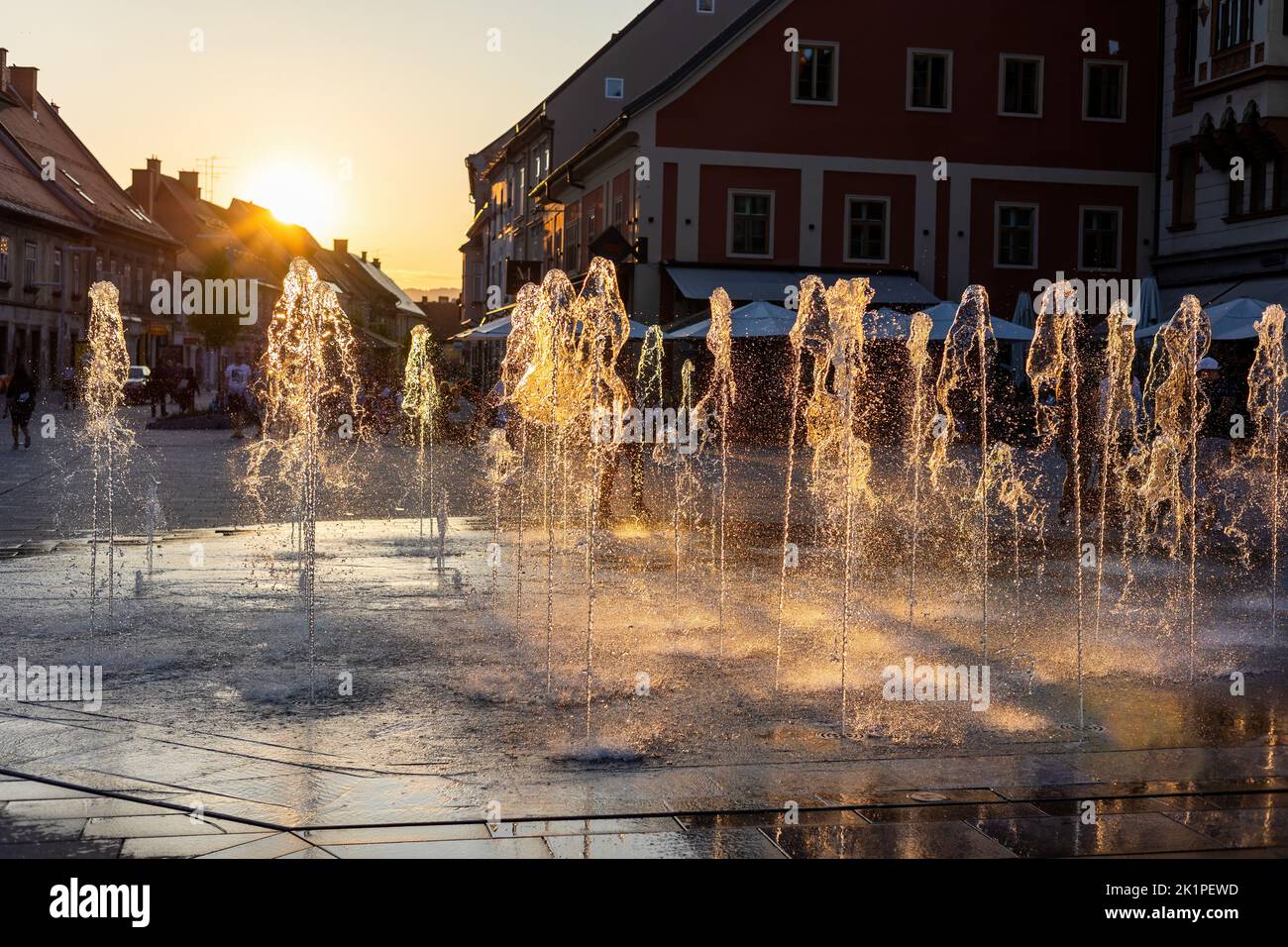 Water spraying from fountain in city of Maribor, Slovenia, at sunset. Stock Photo