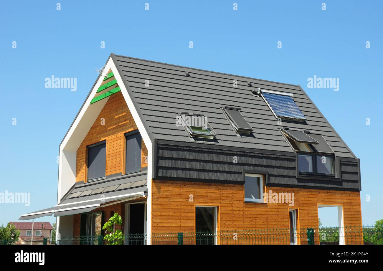 Modern Passive House Exterior. Modern energy efficiency house with skylight windows and solar panels on the roof top. Stock Photo