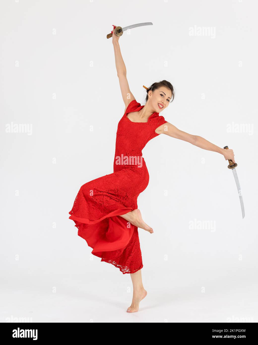 Aikido master woman in red dress with sword, katana on white background. Healthy lifestyle and sports concept. Stock Photo