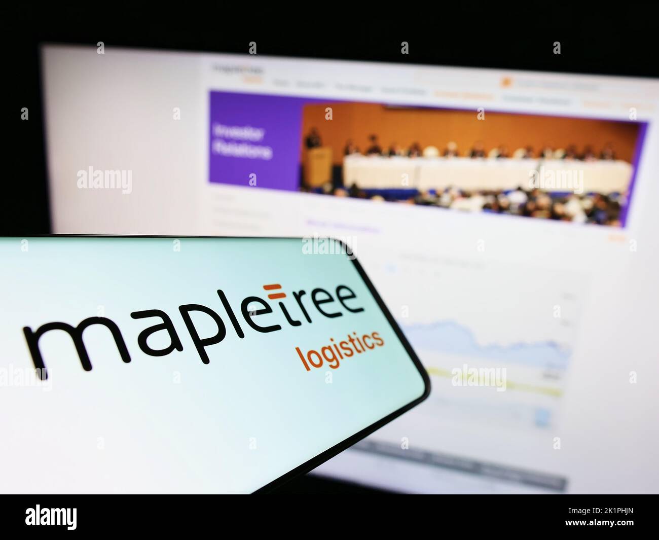 Mobile phone with logo of Mapletree Logistics Trust Management Ltd. (MLT) on screen in front of website. Focus on center of phone display. Stock Photo