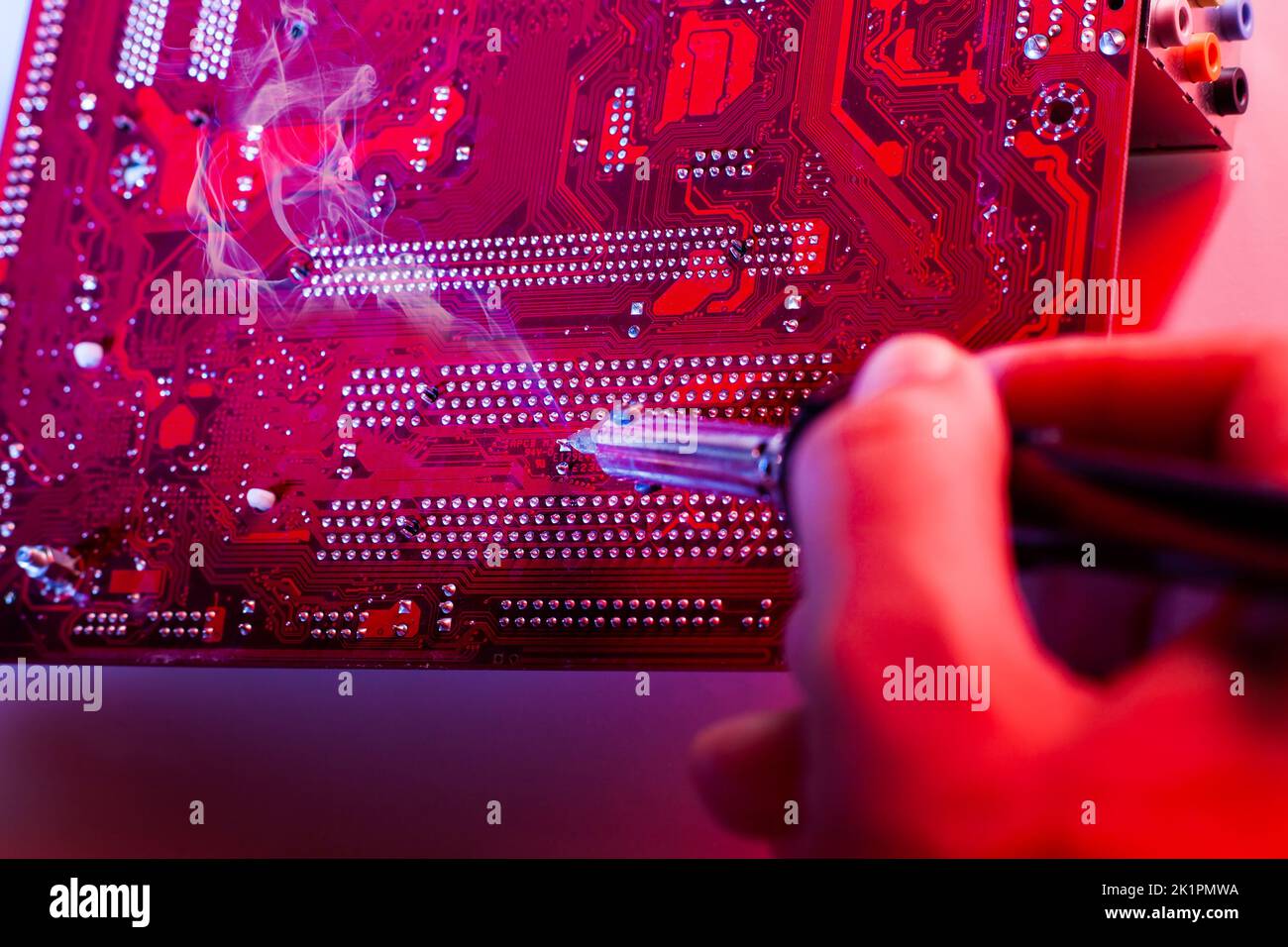 A man soldering a motherboard. Repair and maintenance of desktop ...
