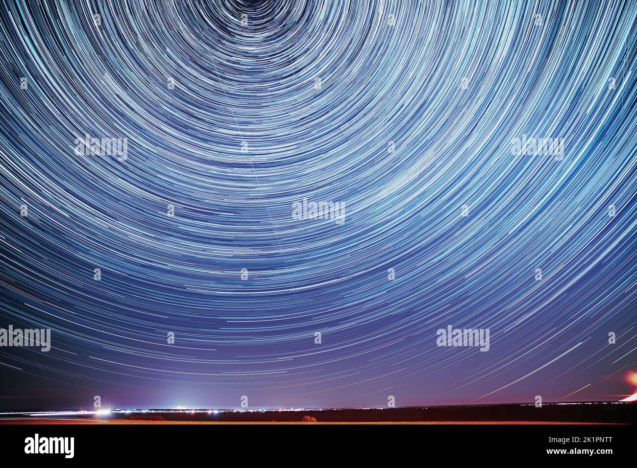 Unusual Amazing Stars Effect In Sky. Trace Of Moon. Spin Of Star And Meteoric Trails On Night Sky. Moonrise Sky Natural Background. Large Exposure Stock Photo