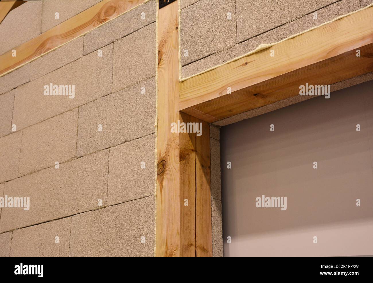 Interior house wall construction with aerated concrete blocks with wooden beams, wooden lintels and insulation foam. Stock Photo