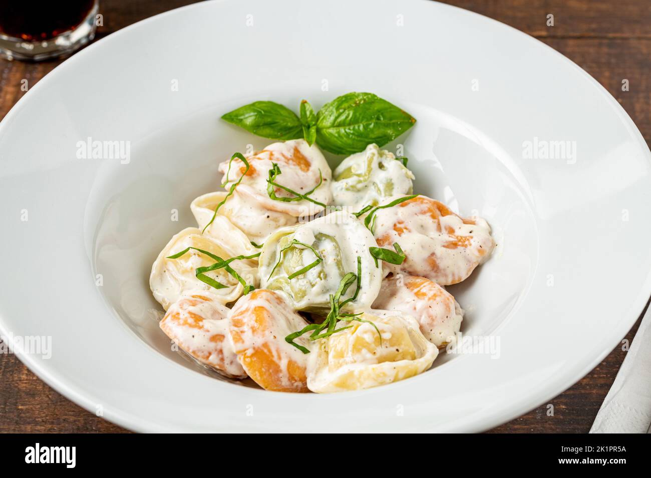 different types of pelmeni or russian dumplings in white plate on wooden background Stock Photo