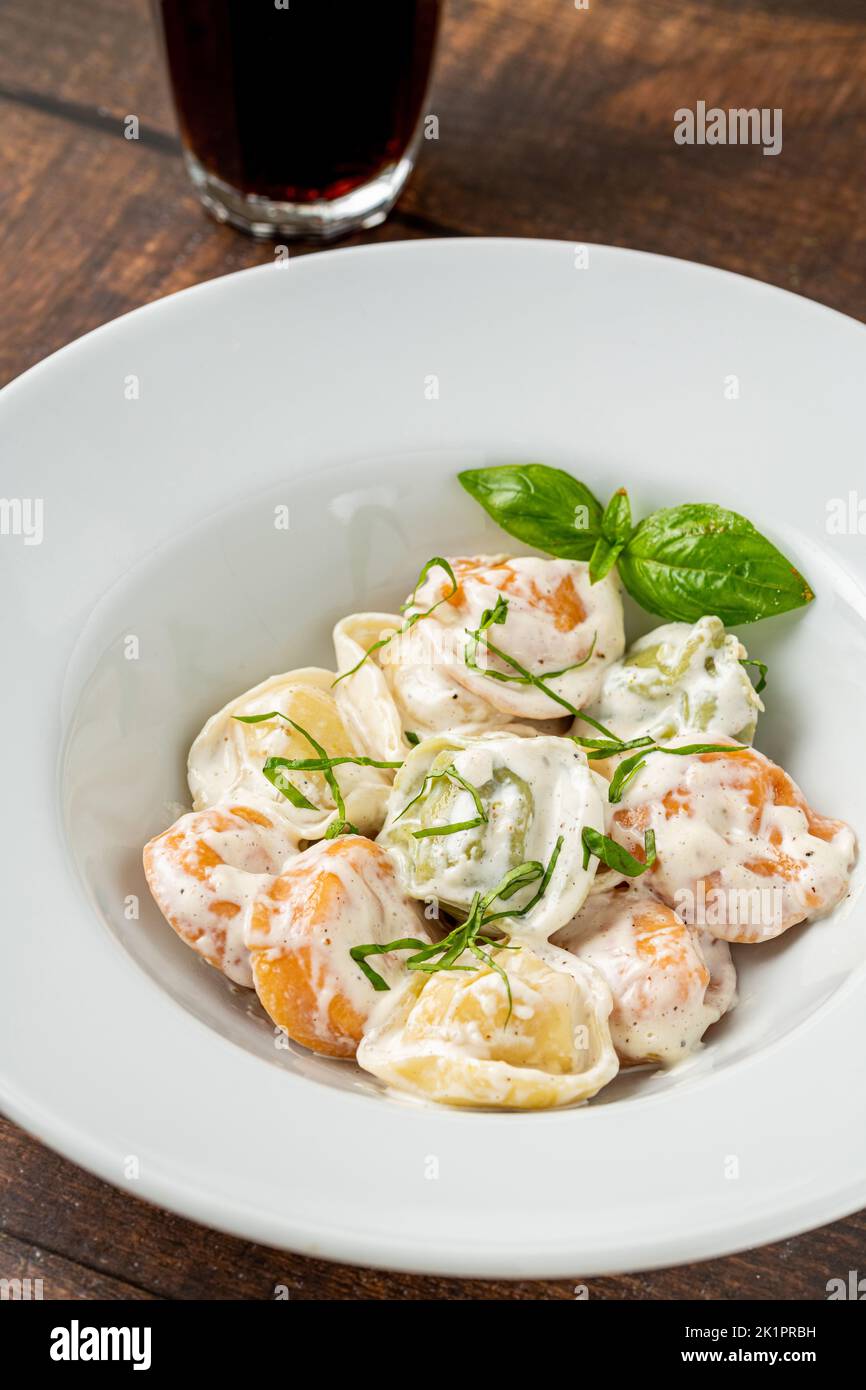 different types of pelmeni or russian dumplings in white plate on wooden background Stock Photo