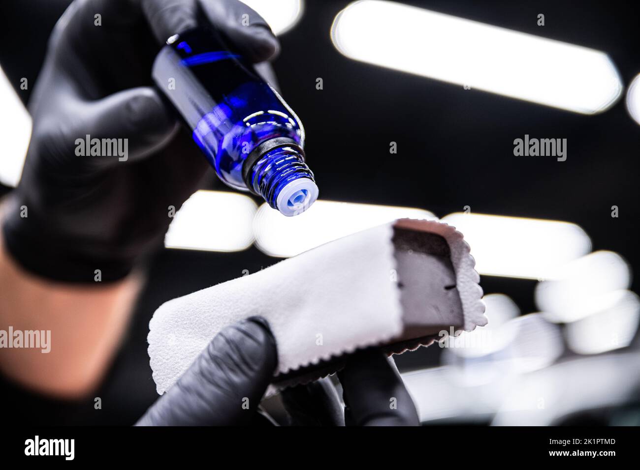 employee of the car detailing studio applies a ceramic coating to a