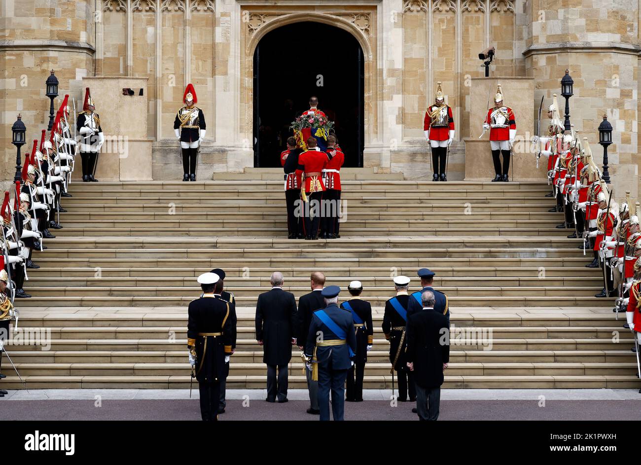 King Charles III, the Princess Royal, the Duke of York, the Earl of Wessex, the Prince of Wales, the Duke of Sussex, Peter Phillips, the Earl of Snowden, the Duke of Gloucester and Vice Admiral Sir Tim Laurence watch as coffin bearers carry the coffin of Queen Elizabeth II into St George's Chapel in Windsor Castle, Berkshire, as it arrives for the Committal Service. Picture date: Monday September 19, 2022. Stock Photo